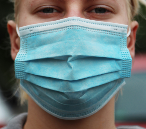 persona joven usando un cubreboca médico durante la pandemia