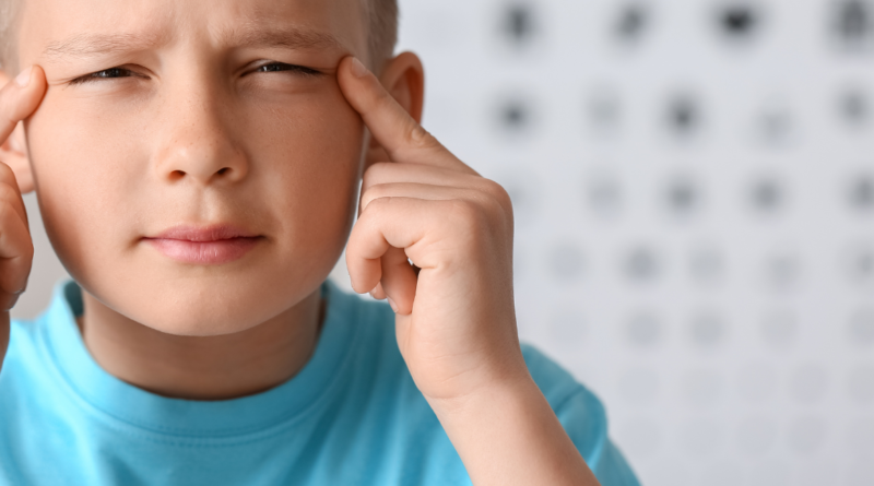 niño con ojos entrecerrados forzando la vista debido a la miopía