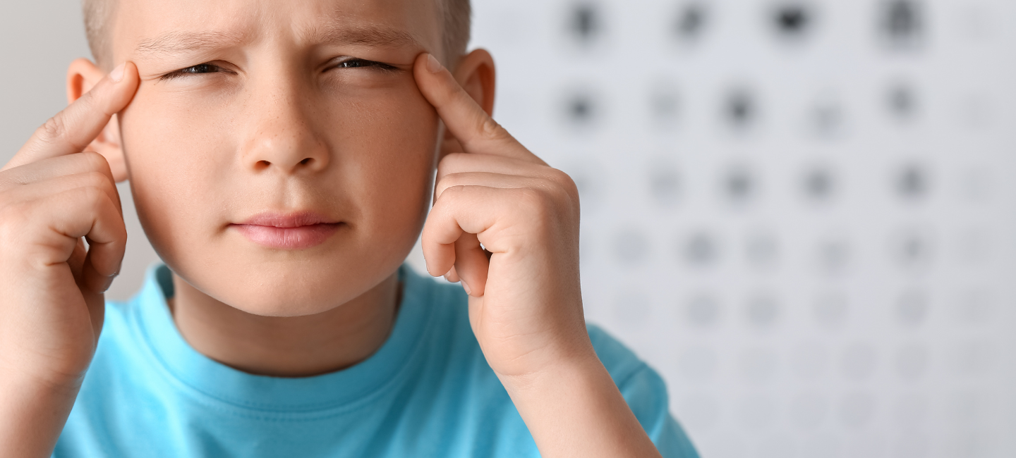 niño con ojos entrecerrados forzando la vista debido a la miopía