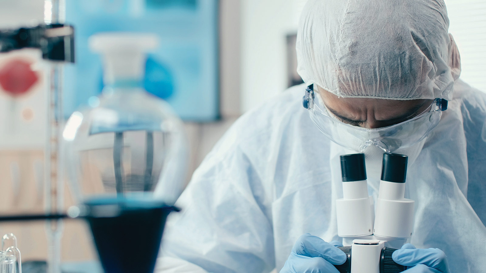 científico médico investigador analizando una muestra en un microscopio en su laboratorio