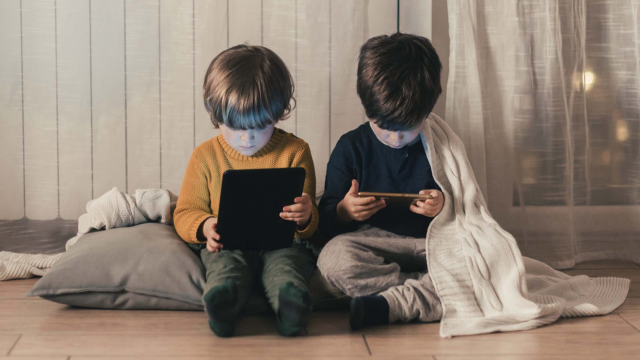 niños viendo pantallas de dispositivos digitales