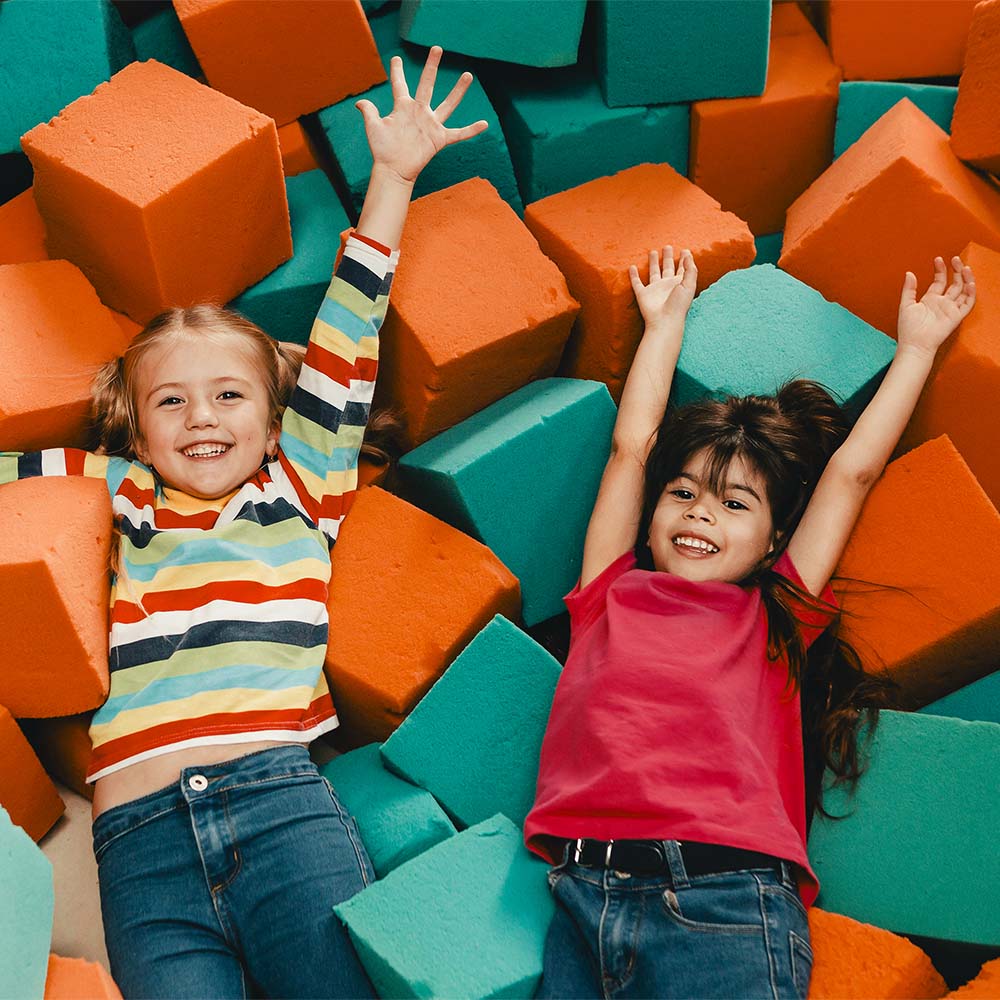 dos niñas felices acostadas sobre cubos de espuma