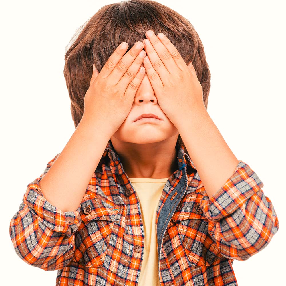 Niño cubriéndose los ojos con las manos