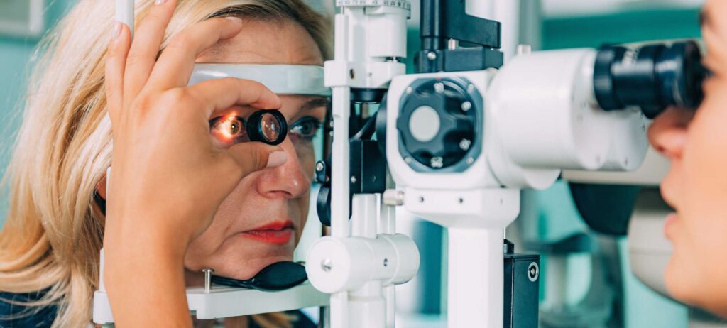 Mujer mediana edad recibiendo examen de los ojos para lente intraocular y miopía alta, con equipo de oftalmología