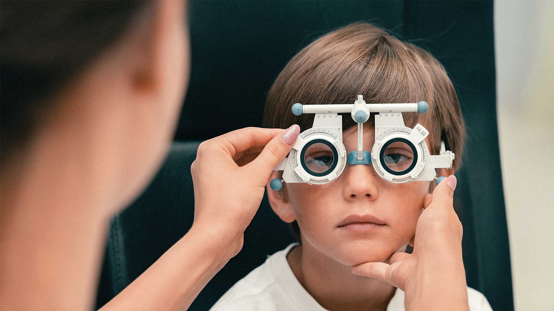 Niño usando lentes de optometría durante examen de la vista
