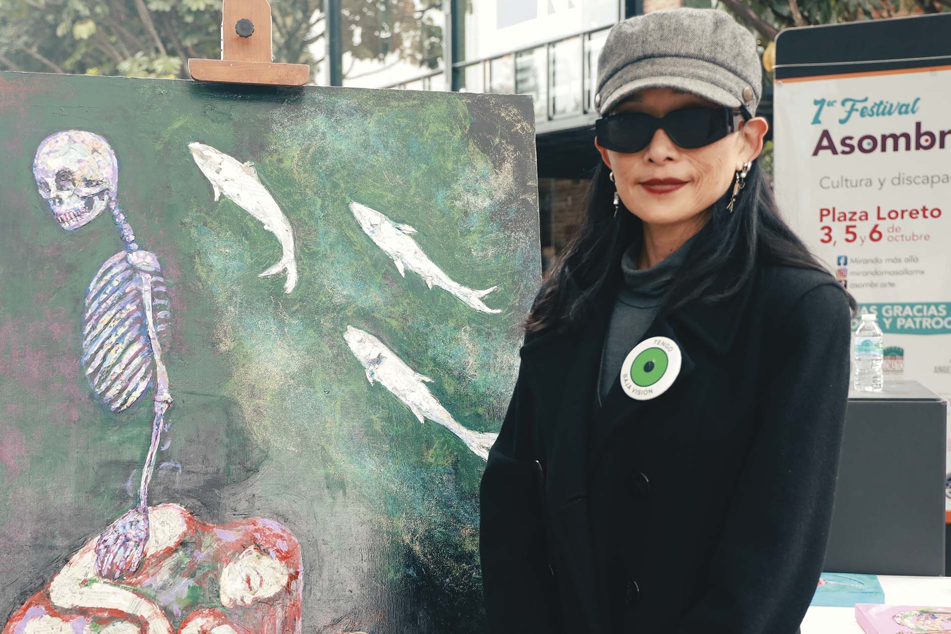 mujer con baja visión posando junto a obra de arte