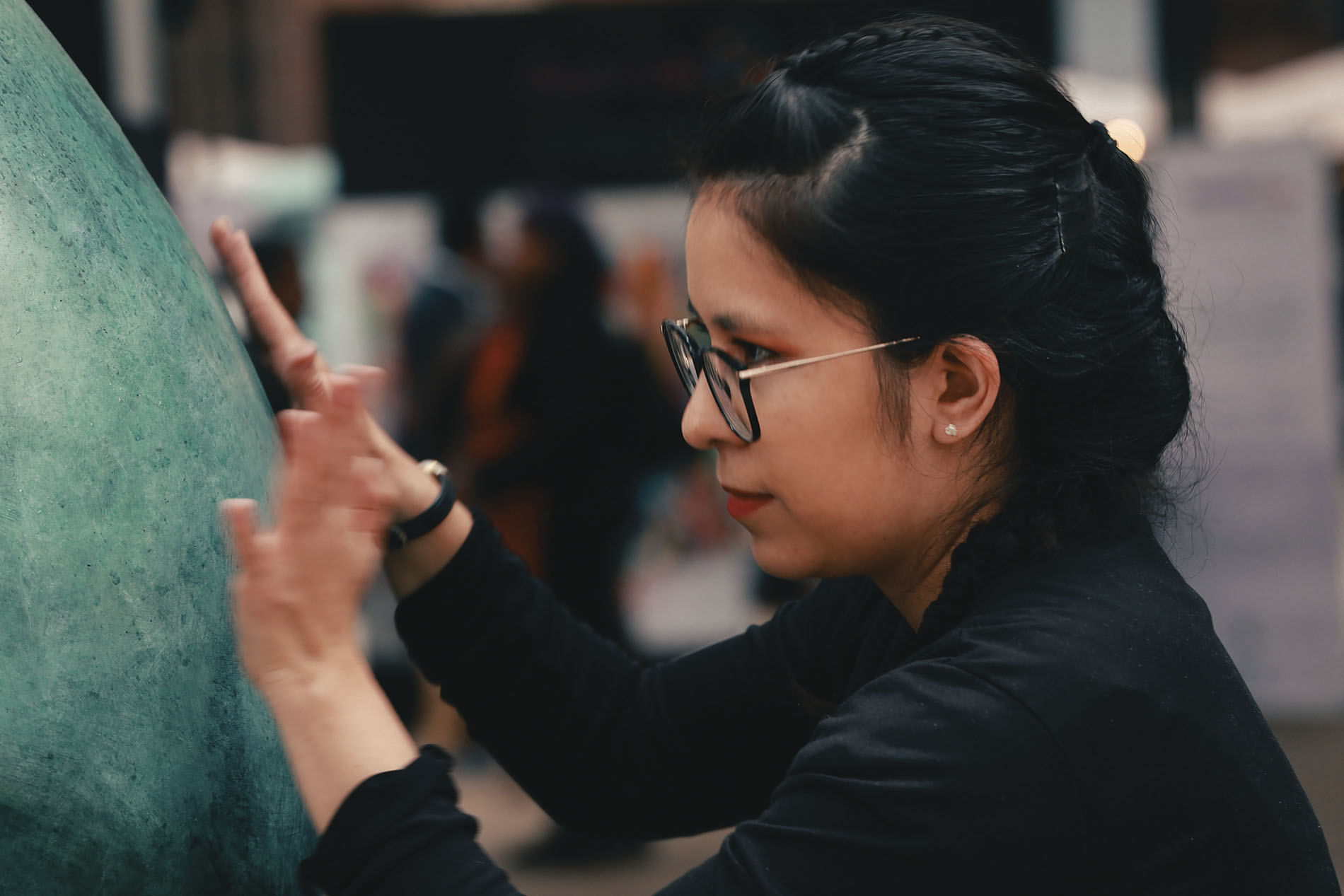 mujer joven con lentes participando en el evento AsombrArte