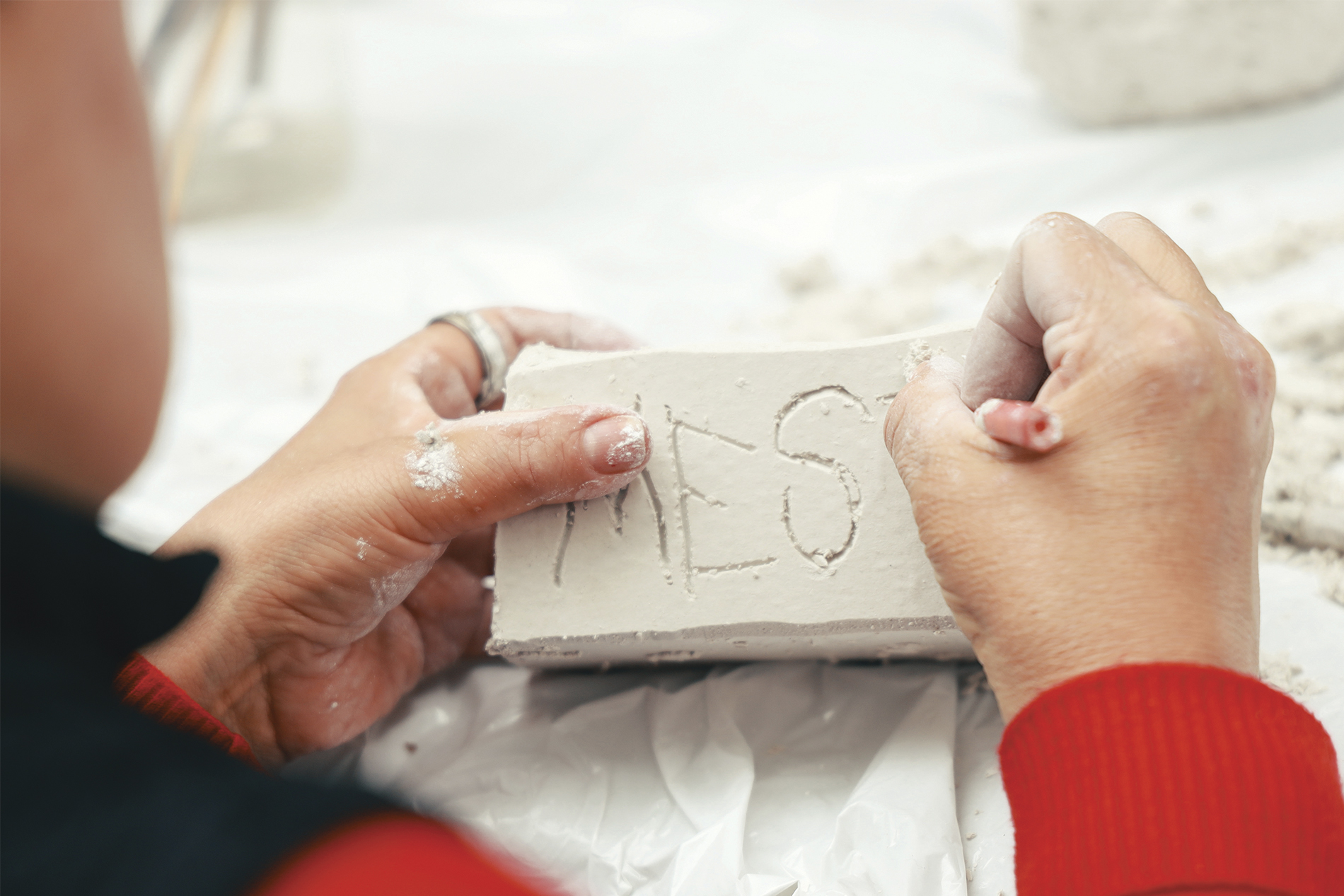 toma cerrada de las manos de una mujer haciendo arte con arcilla
