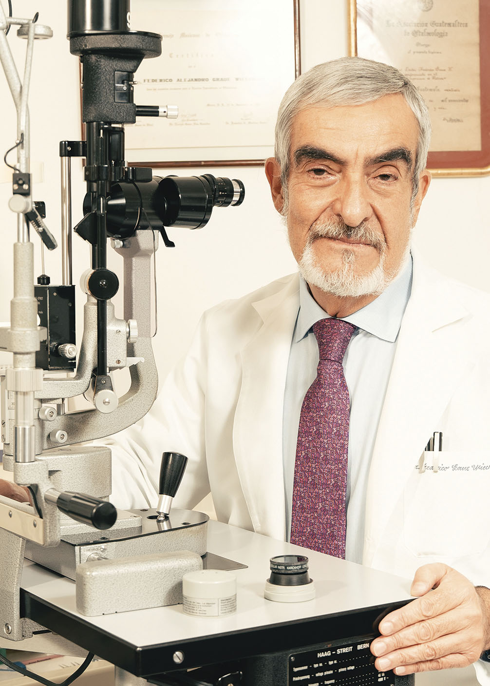 Dr. Federico Graue Wiechers posando ante la cámara junto a equipo médico en su consultorio durante entrevista