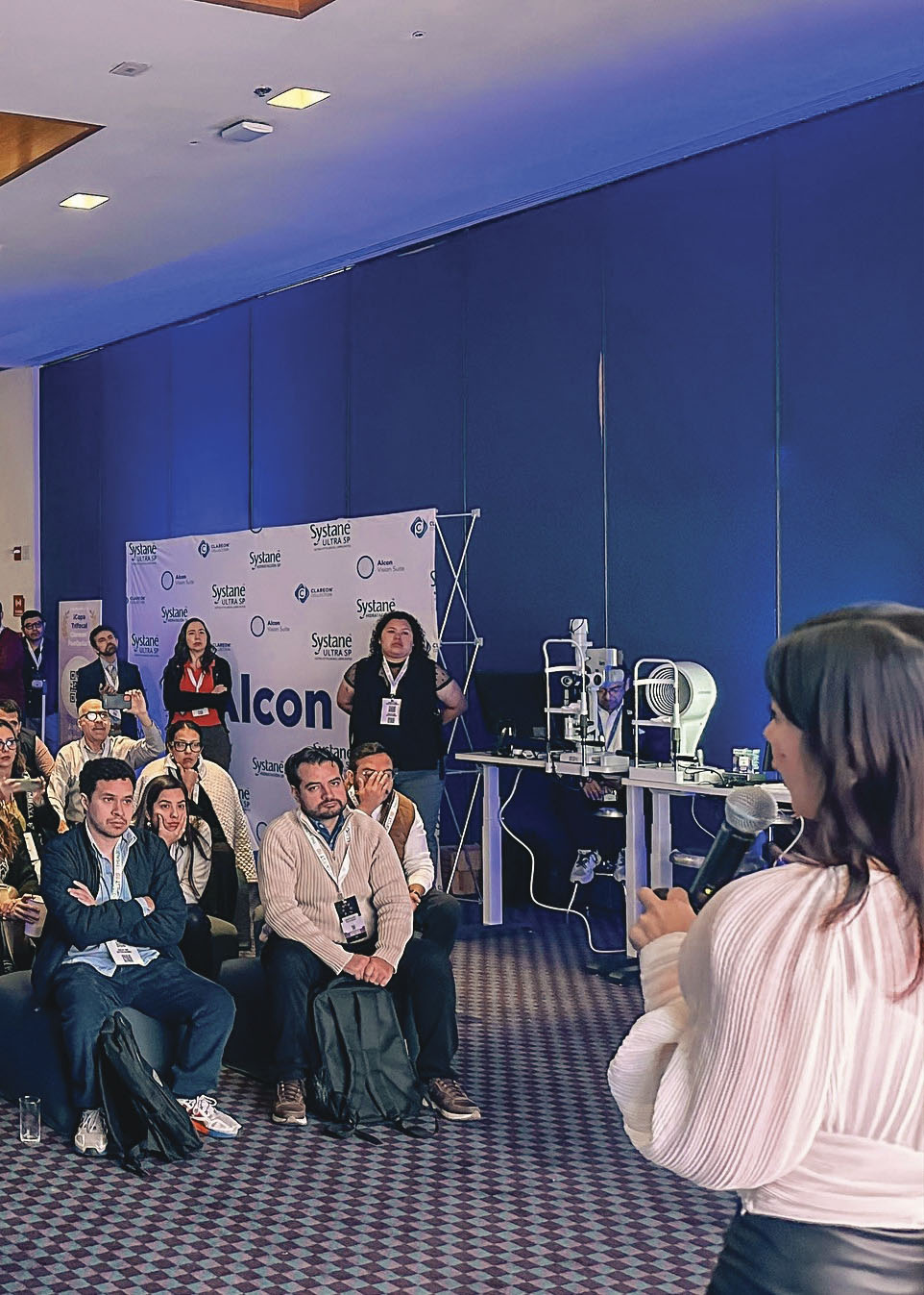 Mujer joven dando una plática con micrófono ante el público durante el evento FACOFEST 2024