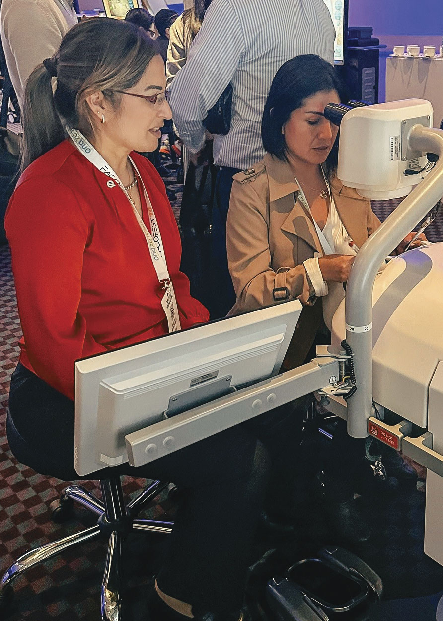 Dos mujeres durante el evento FACOFEST 2024 realizando una práctica de simulación con maquinaria para estudio de los ojos