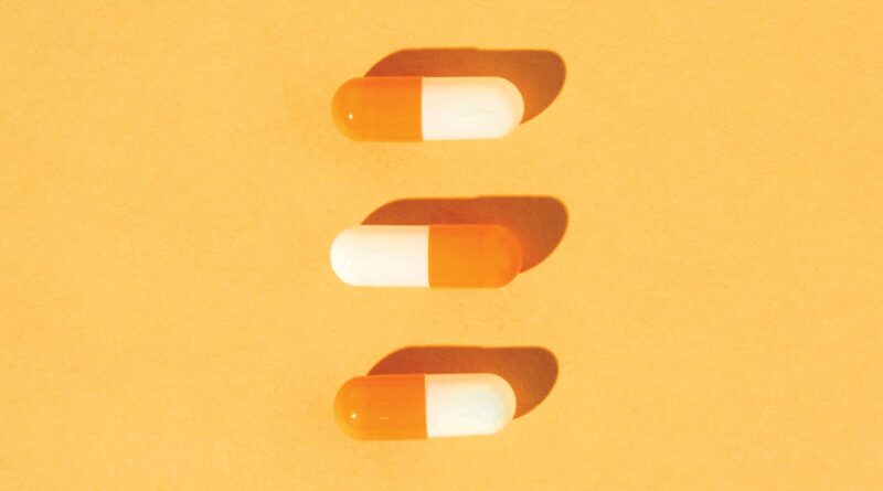 tres cápsulas de medicina alineadas verticalmente sobre fondo anaranjado, representando medicina para el tratamiento del ojo seco