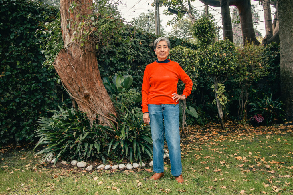 Doctora oftalmóloga Lourdes Arellanes García, parada frente a un árbol en un jardín para entrevista con revista Infoofta