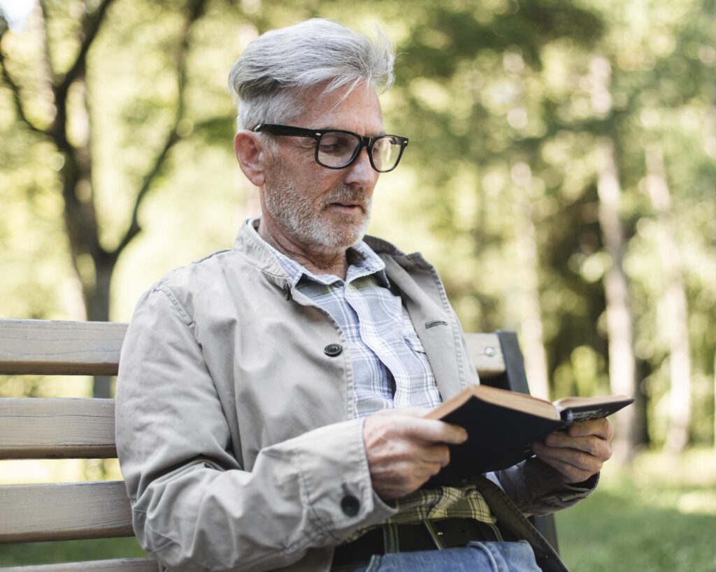 adulto mayor con lentes leyendo